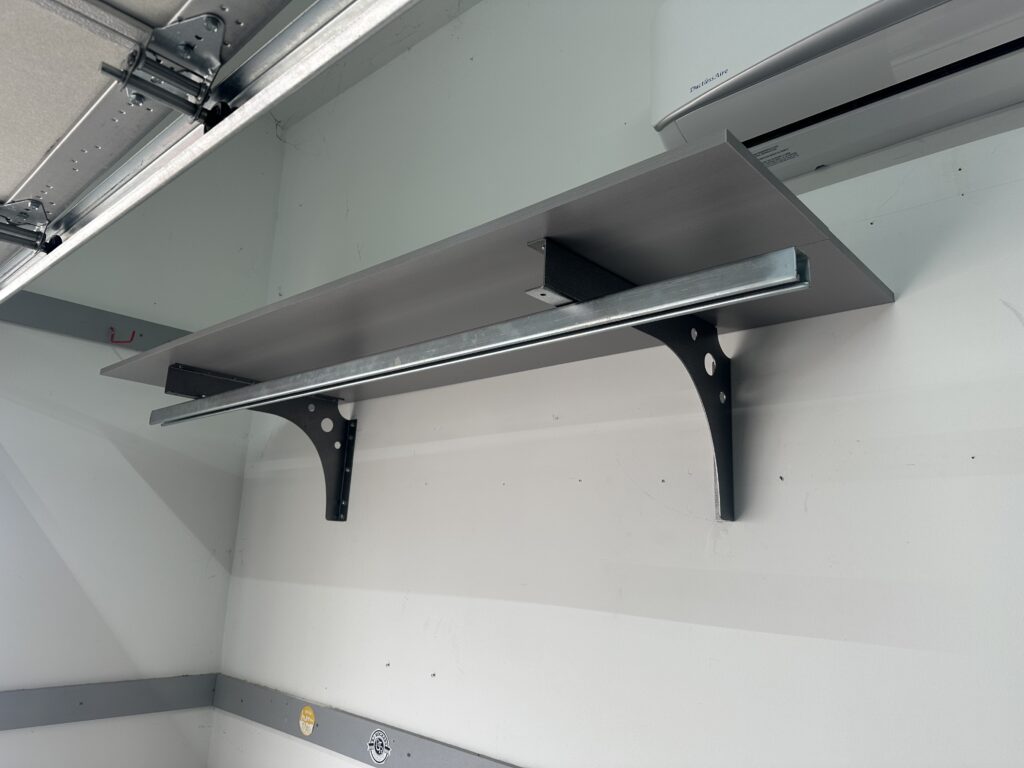 Close up wall mount sliding bike rack under garage door rail.